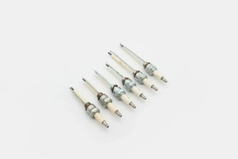 Industrial burner ignition electrode and ionization probe beside a blue gas flame