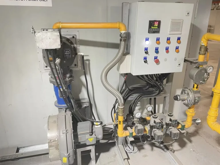 Close view of a gas valve train, burner and control panel for an industrial drying system
