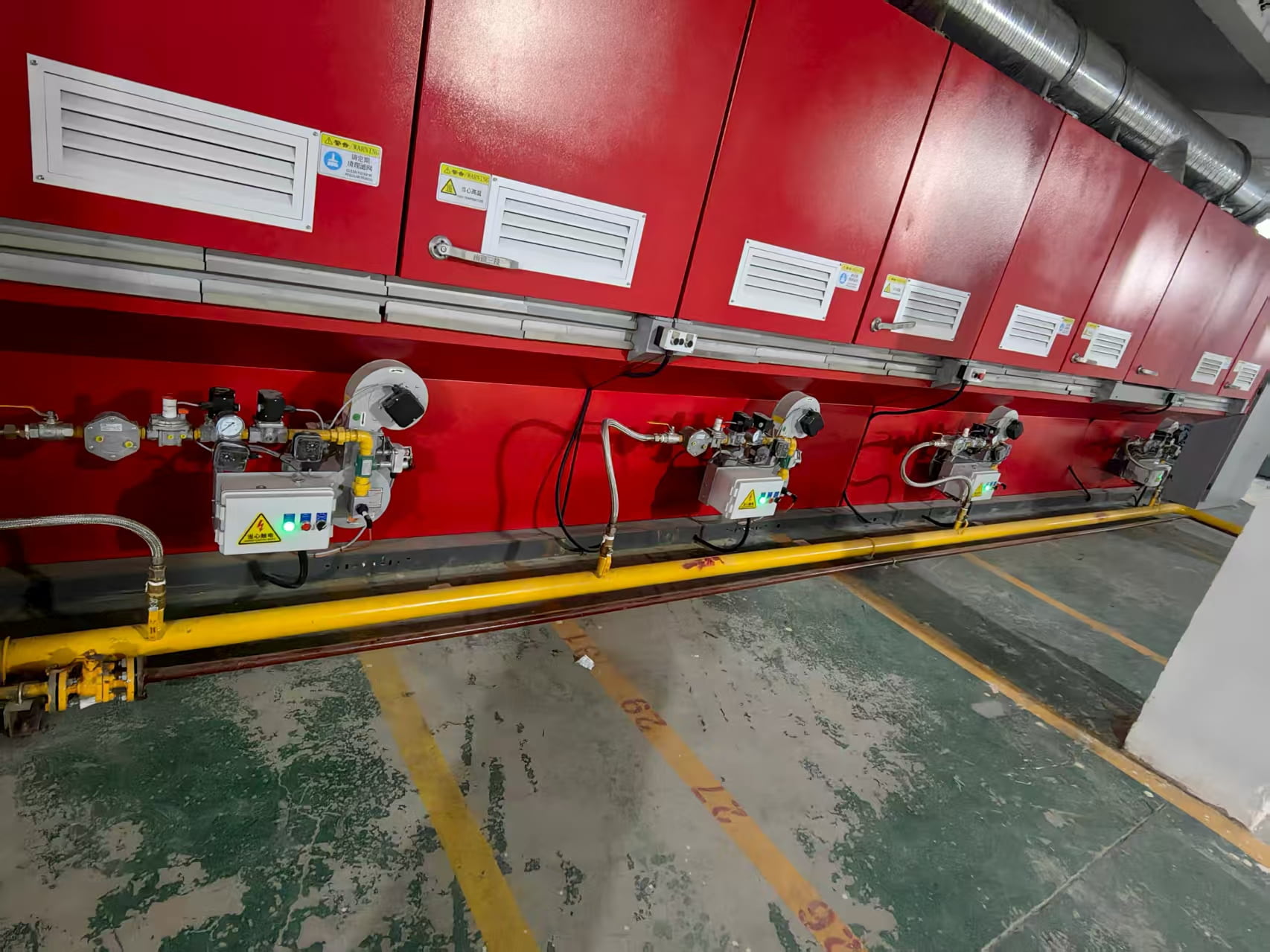 Multiple industrial burners installed along a thermal processing system
