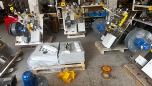 Engineer assembling an industrial combustion system for feed drying, with visible piping and valves.