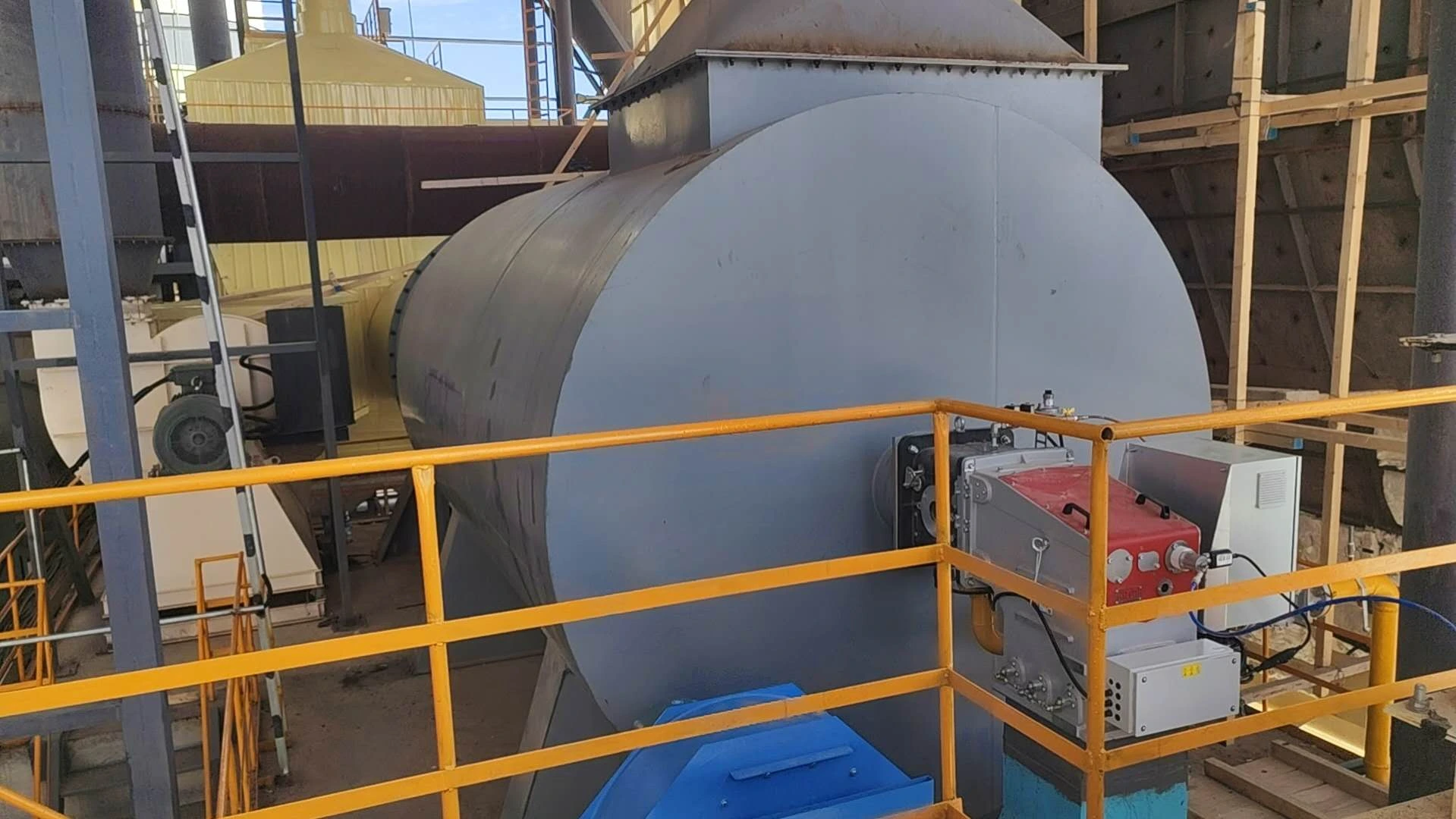 Industrial burner, combustion chamber and fan at a gypsum board production site